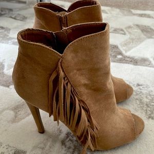 Tan open toe fringe booties.